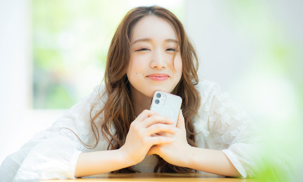 スマートフォンを持ちほほ笑む若い女性